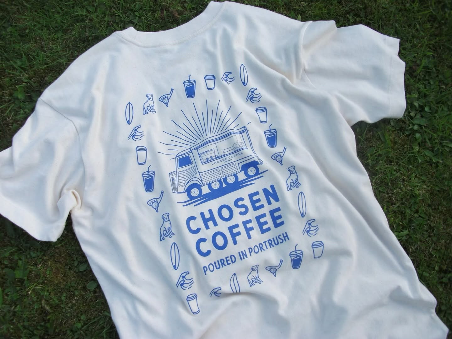 Cream Chosen Coffee t-shirt laid on grass, blue van illustration